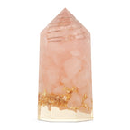 Pink crystal with gold inclusions on a white background