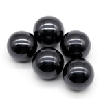Five glossy black spheres on a white background