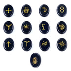 Set of black stones with yellow astrological symbols on a white background