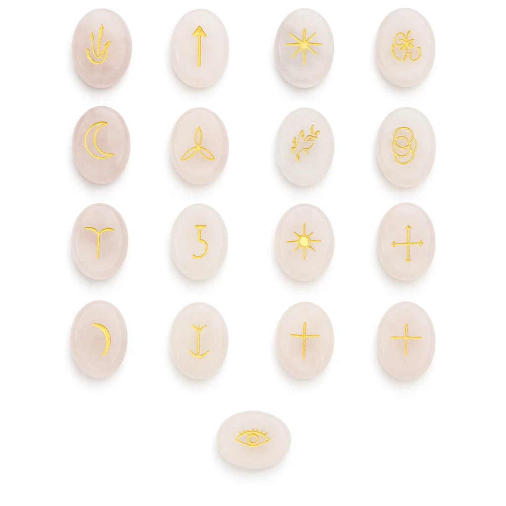 Set of pink stones with gold astrological symbols on a white background