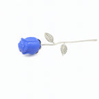 Blue rose-shaped brooch with silver leaves on a white background