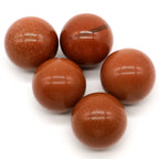 Five brown speckled balls on a white background