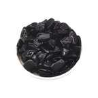 Black stones in a white bowl on a white background