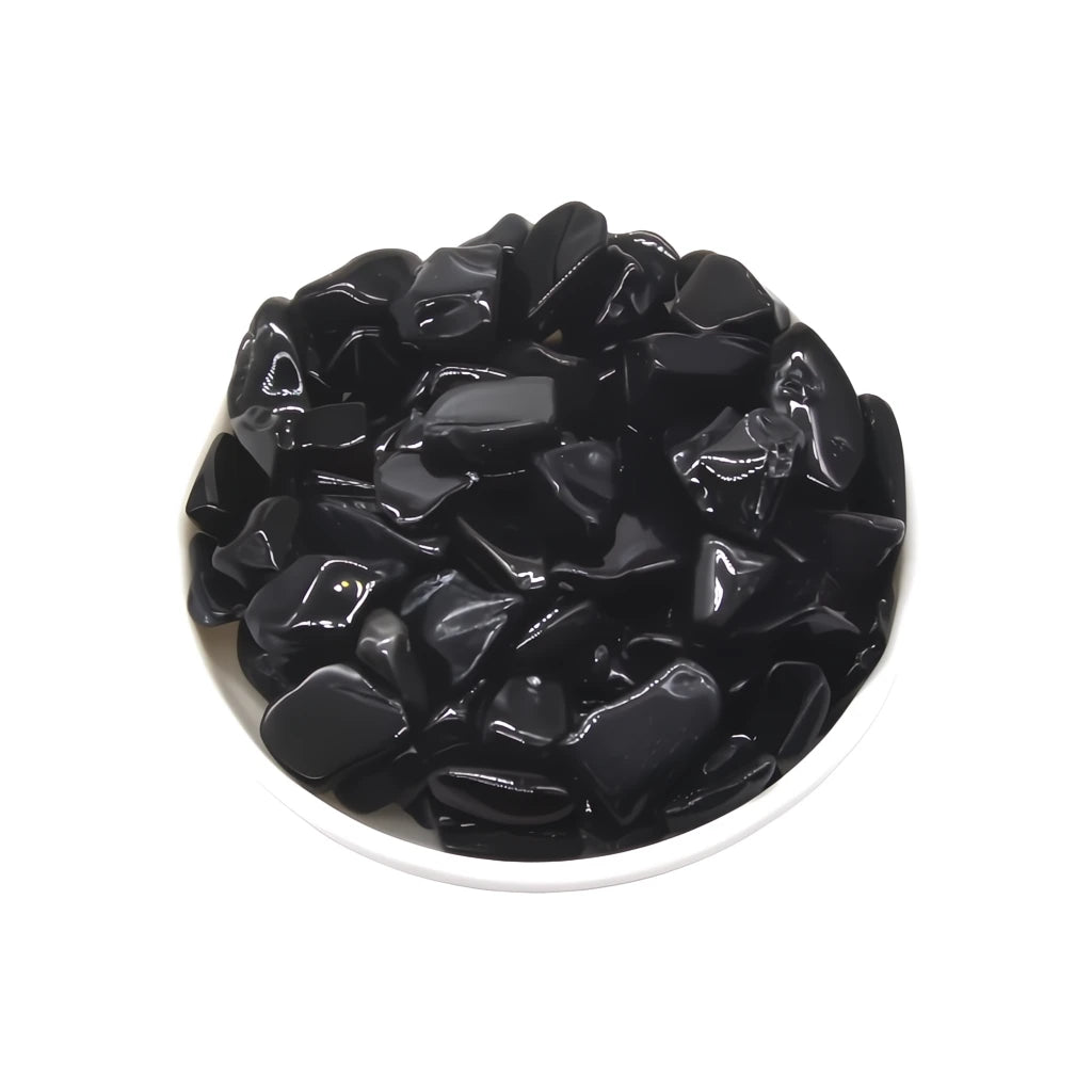 Black stones in a white bowl on a white background