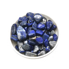 White bowl filled with blue stones on a white background