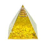 Pyramid-shaped object with a spring on top, filled with yellow material, on a white background