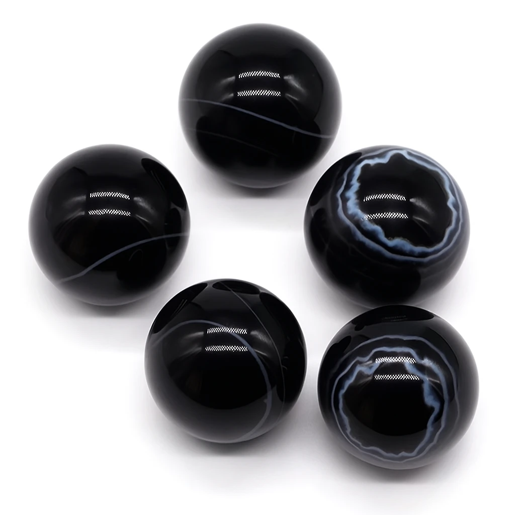 Set of five black marble-like beads on a white background