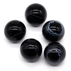 Set of five black marble-like beads on a white background