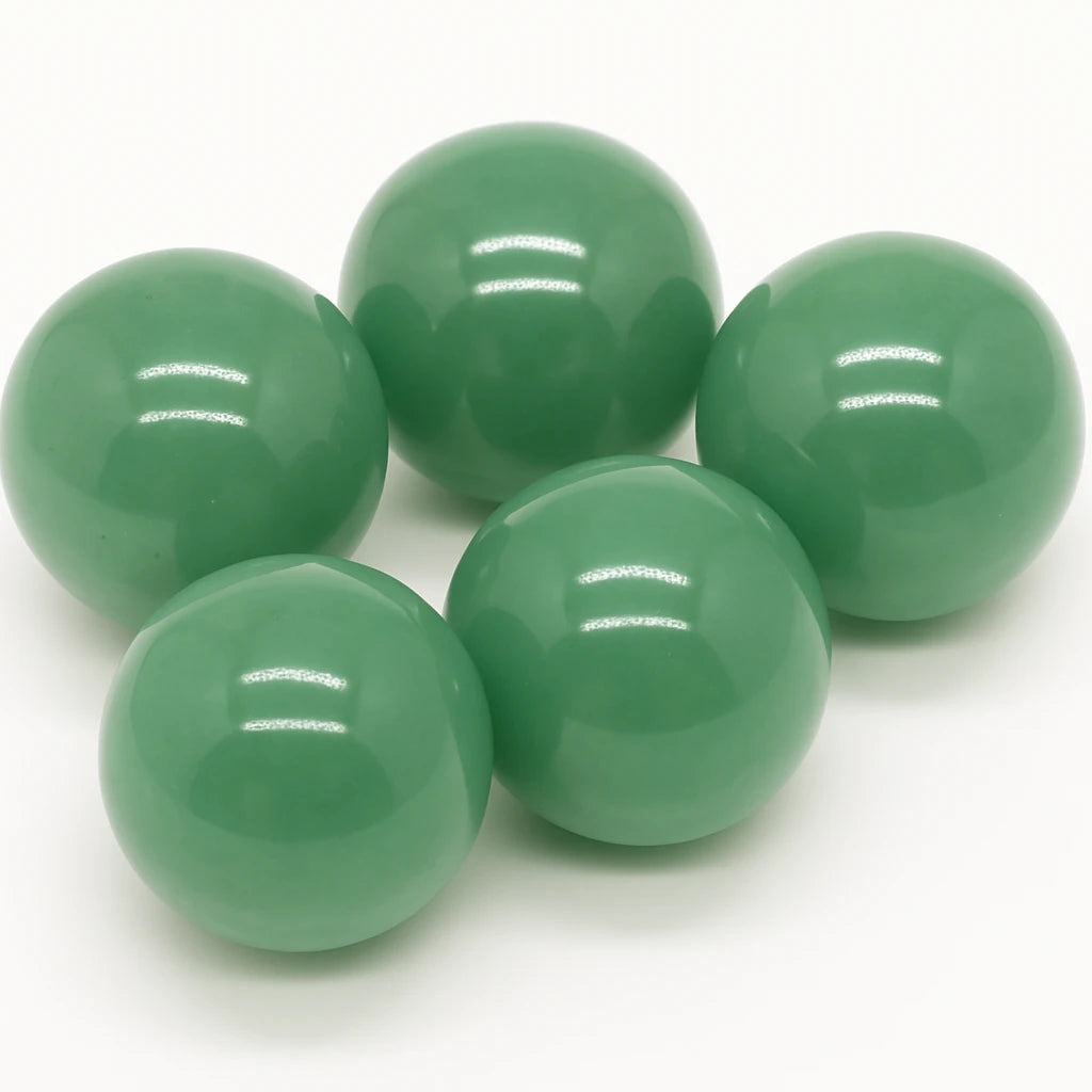 Five green glass marbles on a white background