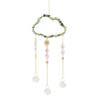 Dreamcatcher with green beads, gold accents, and white pearls on a white background