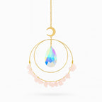 Decorative hanging ornament with a colorful teardrop-shaped crystal, gold chain, and pink stones on a white background.