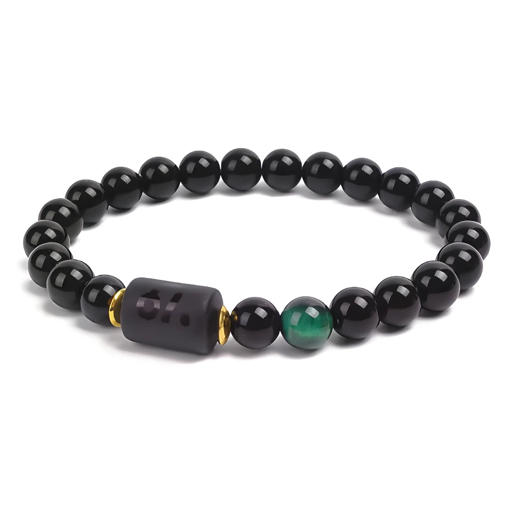 Black beaded bracelet with a green accent bead on a white background