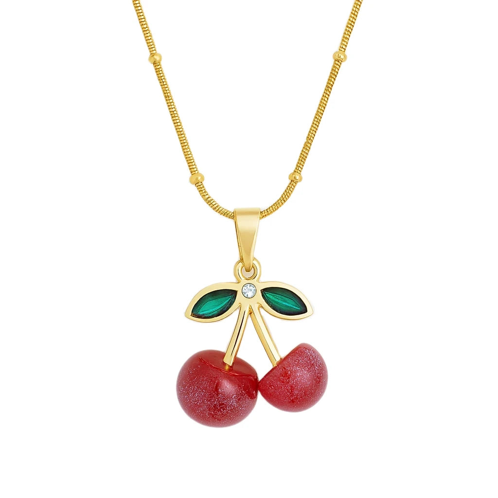 Gold necklace with cherry pendant on a white background