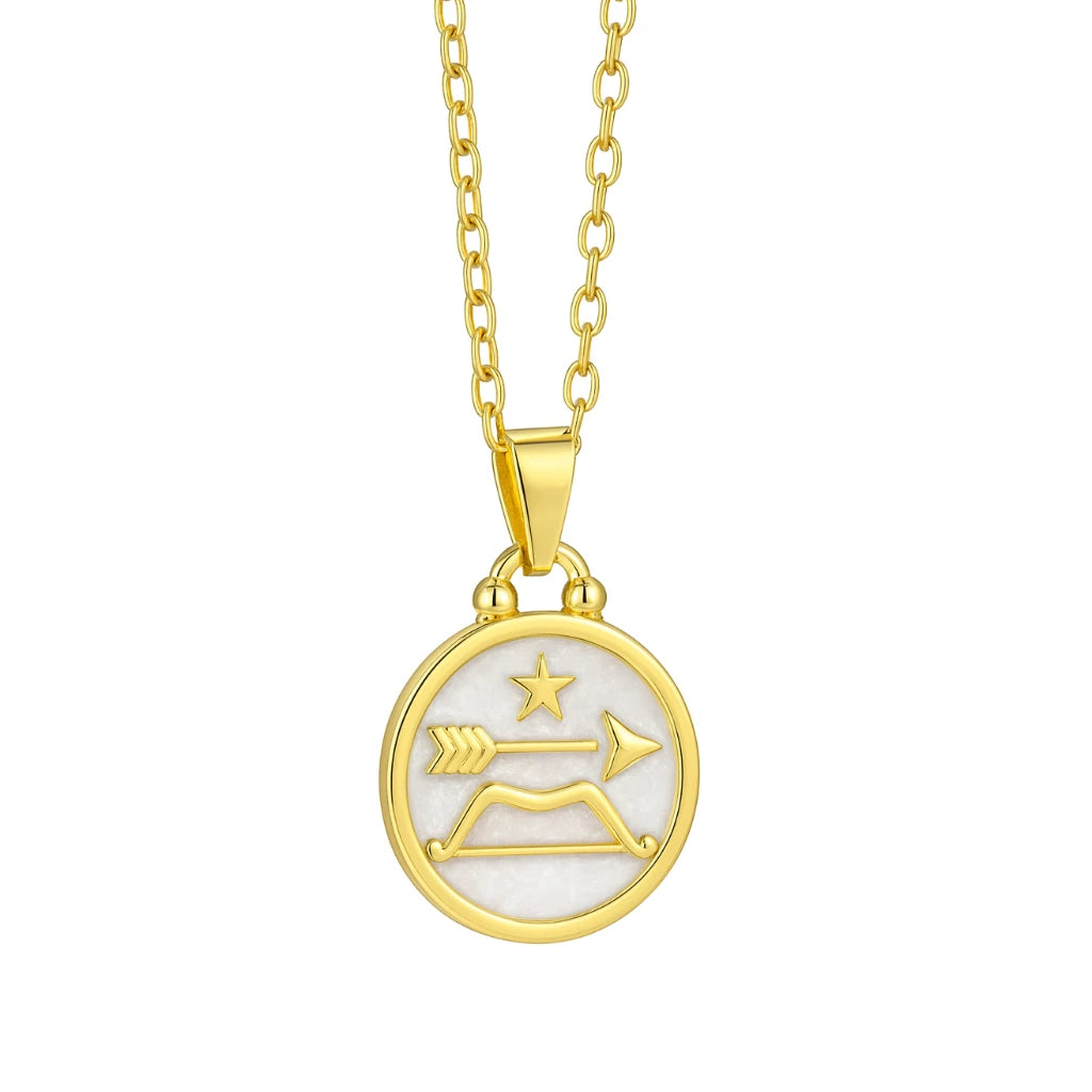 Gold necklace with a circular pendant featuring astrological symbols on a white background