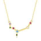 Gold necklace with a zodiac sign pendant featuring colorful gemstones on a white background
