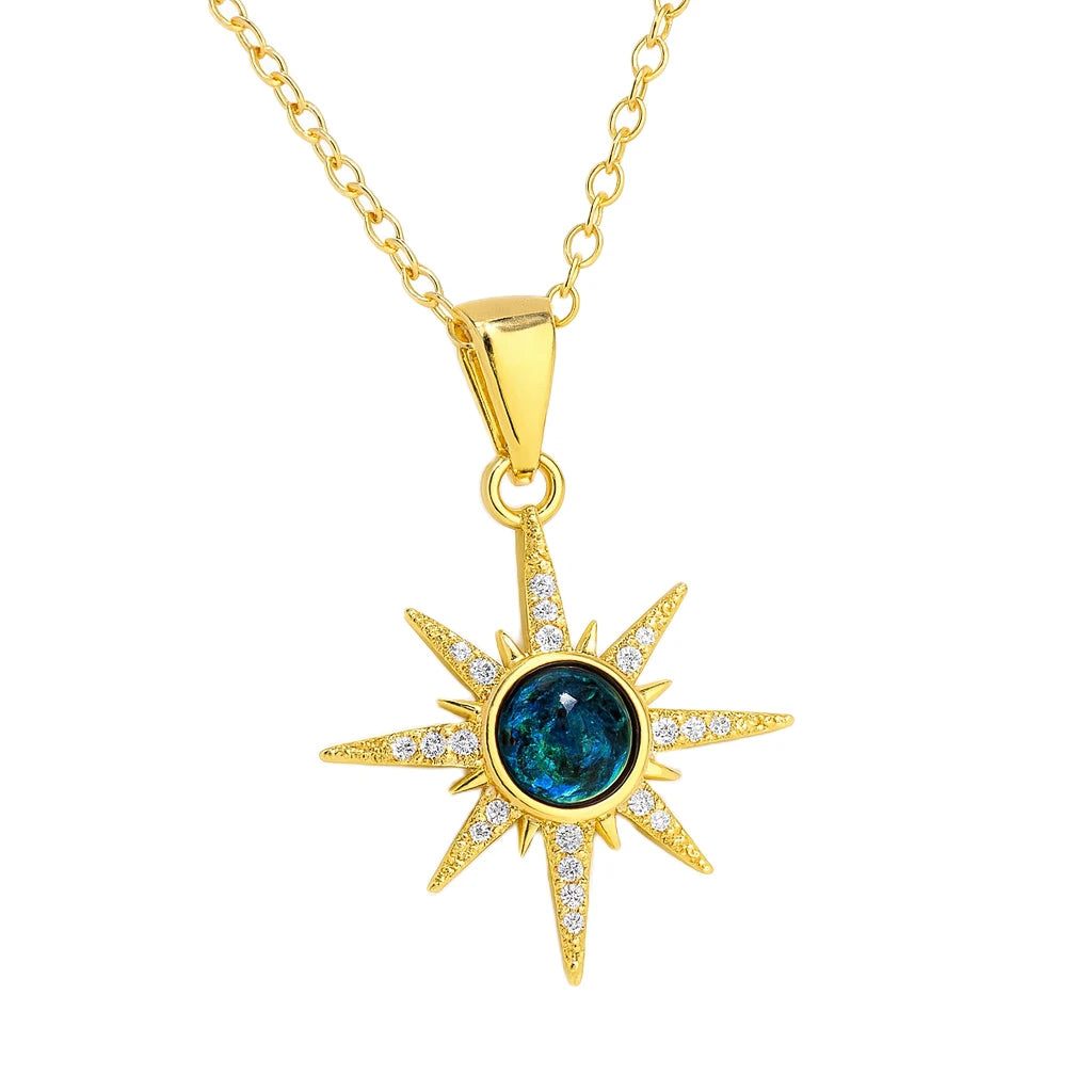 Gold necklace with a star-shaped pendant featuring a blue gemstone on a white background