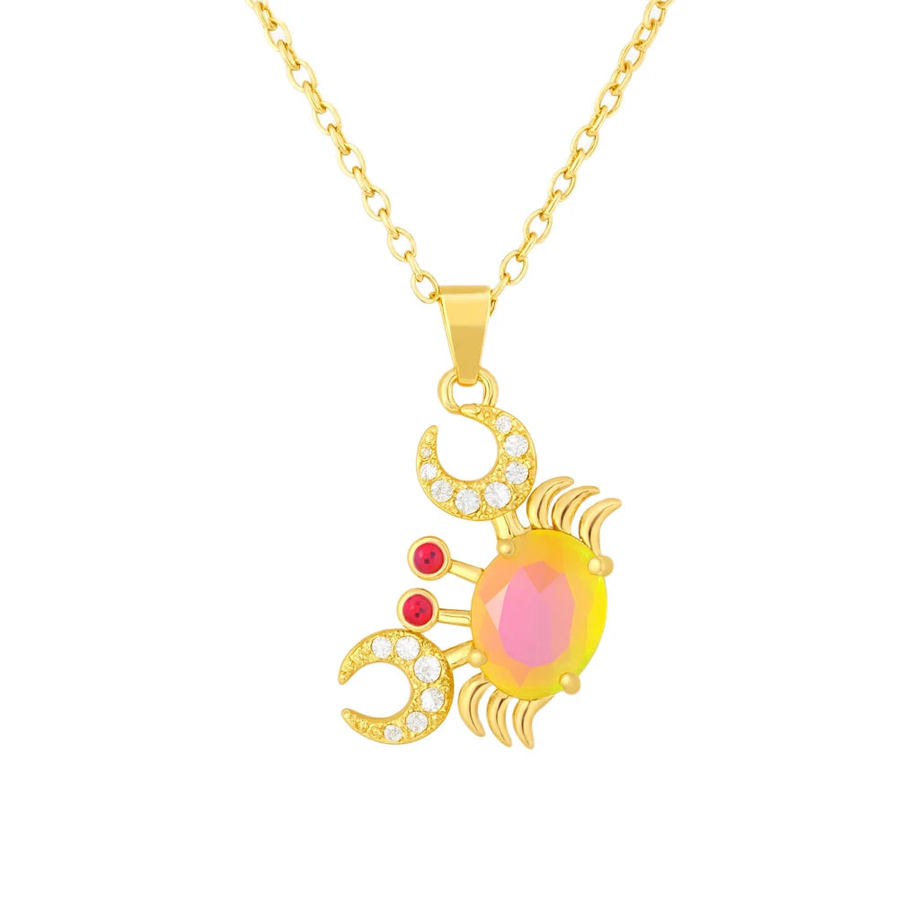 Gold crab-shaped pendant necklace with pink gemstone on a white background