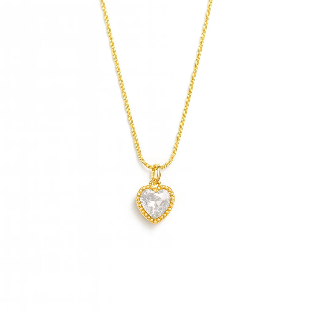 Gold necklace with a heart-shaped pendant on a white background