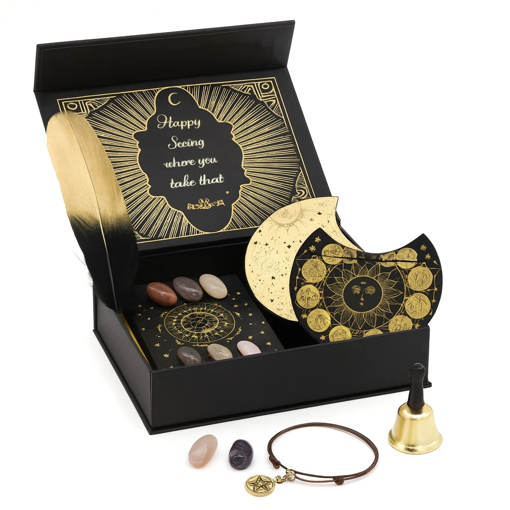 Decorative set with black box, gold crescent moon, stones, bell, and bracelet on a white background